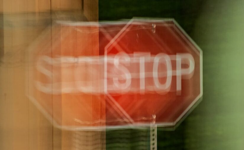 A blurred stop sign at night as if seeing double vision as John Frangie, M.D. explains the side effects of double vision